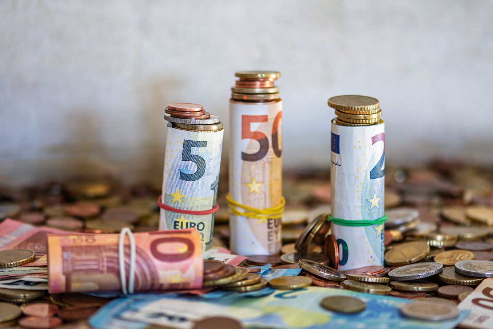 Gerollte Euro-Banknoten und Münzen